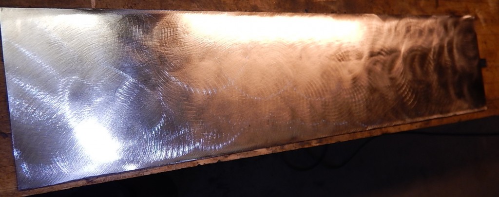 When you buy steel at the steel yard, it comes coated in "mill scale" that's harder than the steel, and it's really hard to grind off. But once you get rid of it, you can experiment with scratch patterns